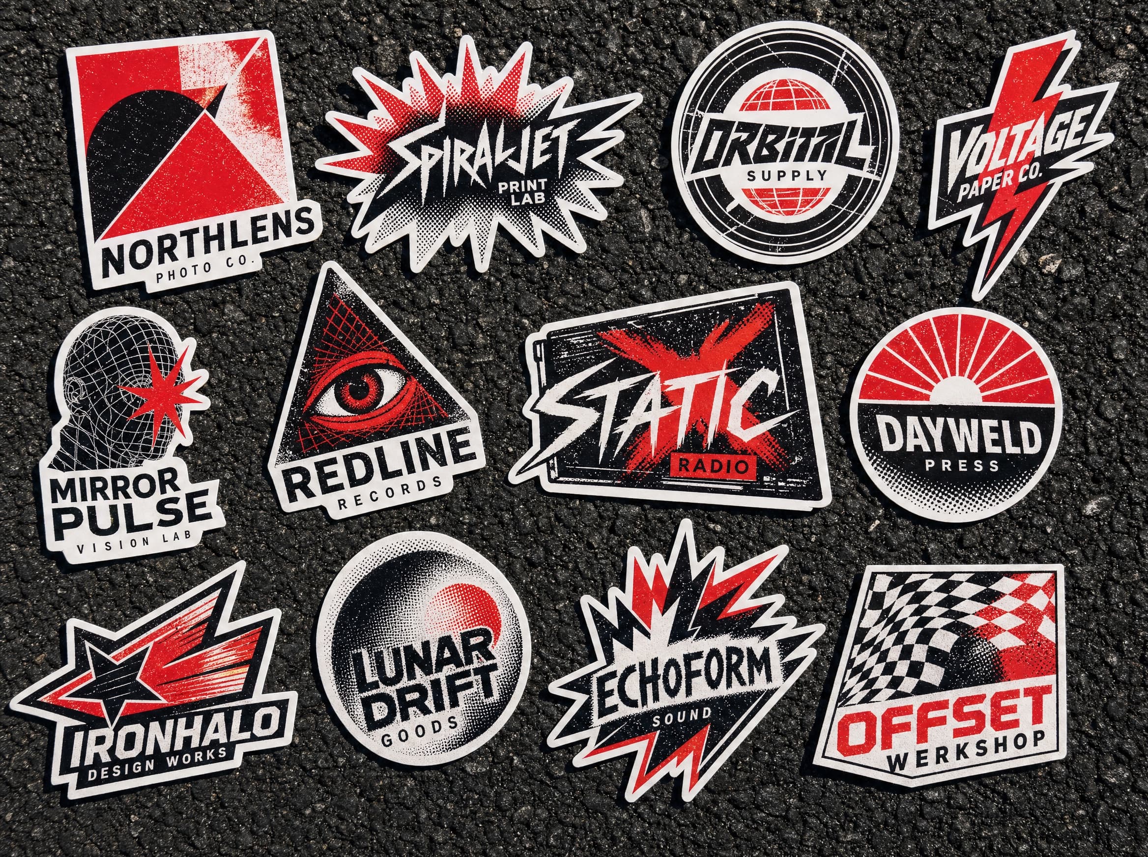 Die-cut vinyl stickers scattered on asphalt, printed in red and black.